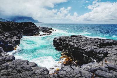 Scenic view of rocks in sea against sky