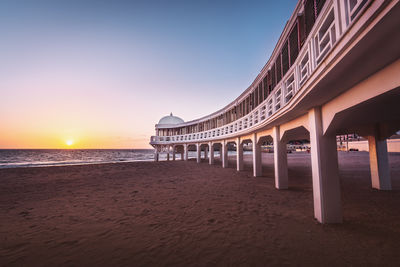 Bridge over sea against sky during sunset