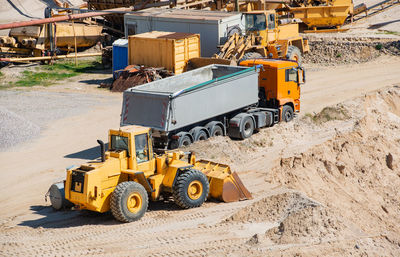 High angle view of earth mover and truck at construction site