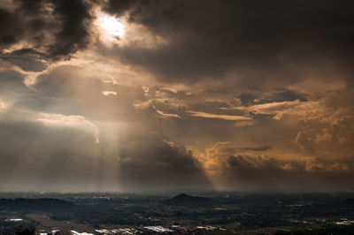 Sunlight streaming through clouds over sea
