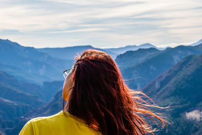 Rear view of woman against mountain range