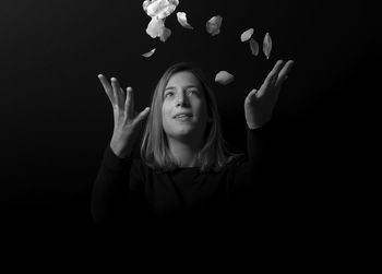 Portrait of young woman against black background