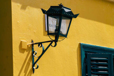 Low angle view of yellow lamp mounted on wall