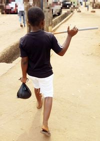 Rear view of boy walking in city