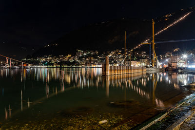 Illuminated bridge over river at night