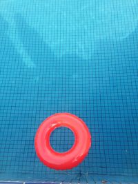 High angle view of red inflatable ring floating on swimming pool
