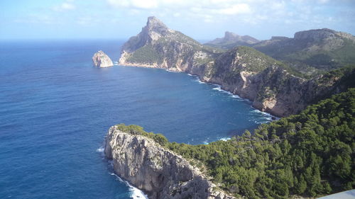 Scenic view of sea and mountains against sky