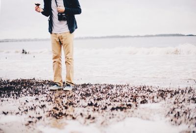 Low section of woman standing on beach