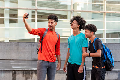 Fiends taking selfie while standing outdoors