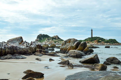 Rock formations by sea against sky