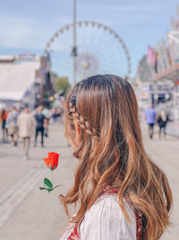 Side view of young woman looking away while standing in city