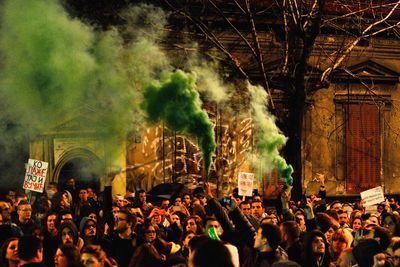 Group of people with green distress flare at music concert