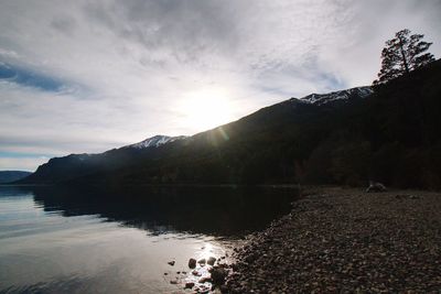 Scenic view of lake by mountains against sky