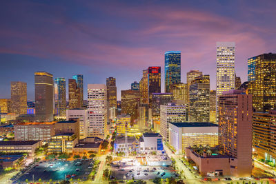 Illuminated buildings in city against sky