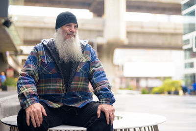 Portrait of man sitting in city