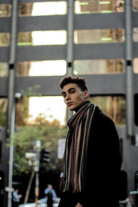 Portrait of stylish young man standing in city