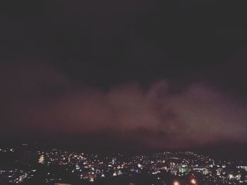 Illuminated city against sky at night