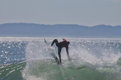 Man surfing on sea against sky