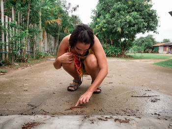 Young woman looking at insect on the ground