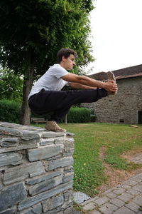 Side view of young man against wall