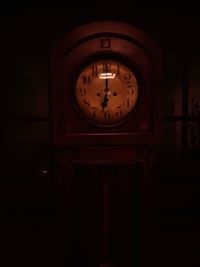 Close-up of clock on wall in darkroom