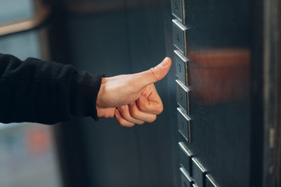 Close-up of hand holding metal door