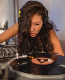 Close-up of fashionable young woman playing music at home