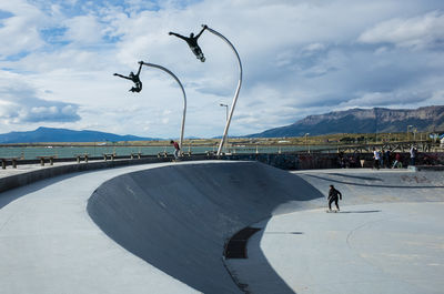 People flying by mountain against sky