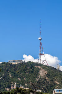 Low angle view of communications tower against blue sky