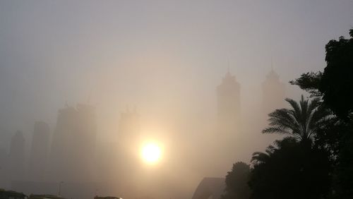 Silhouette of temple against sky during foggy weather