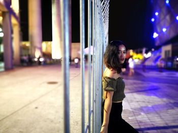 Side view of woman looking away in city at night