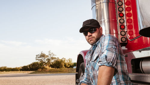 Portrait of man standing by truck outdoors