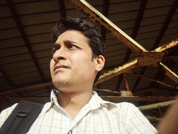 Low angle view of young man under shed