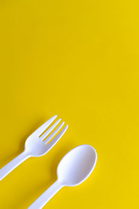 High angle view of spoon against yellow background