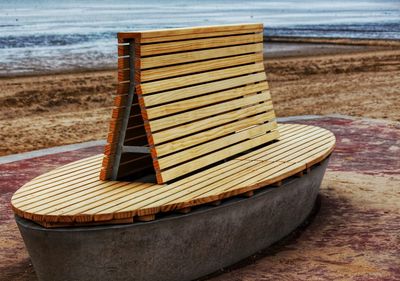 Close-up of deck chairs on beach against sky