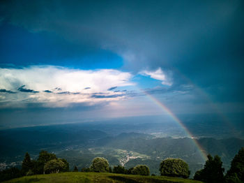 Scenic view of rainbow over landscape against sky