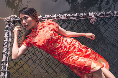 Portrait of young woman looking through fence