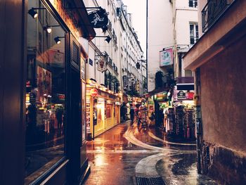 Wet city streets amidst buildings at dusk during rainy season