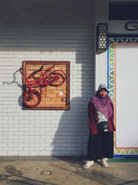 Full length of man standing against wall