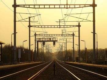 Railroad tracks against sky during sunset