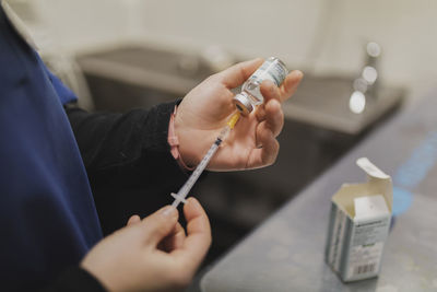 Cop view of professional veterinarian woman doctor holding syringe