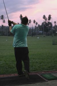 Golfer playing on field at dusk