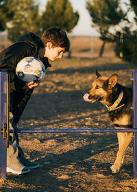 Funny obedience dog expression sticking out tongue looking child teaching how to jump over obstacles