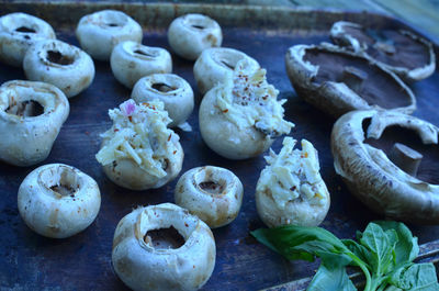 Preparing raw white stuffed mushrooms for appetizers for grilling outdoors 