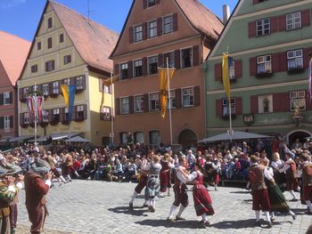 Crowd in city against sky