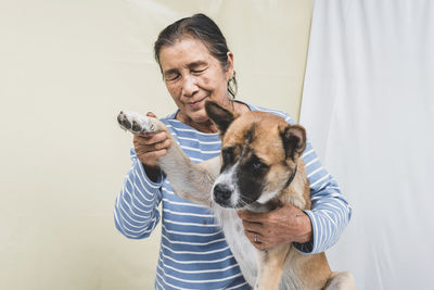Close-up of senior woman holding dog outdoors