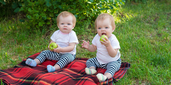 Portrait of siblings sitting on lawn