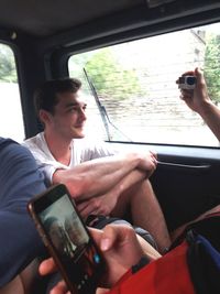 Young man using mobile phone while sitting in car