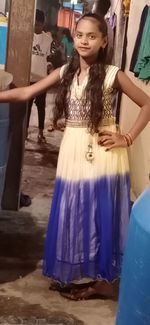 Full length of smiling young woman standing outdoors