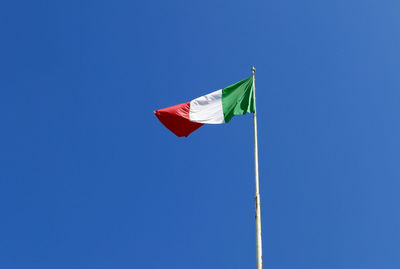 Bright and sunny italian flag waving against the blue sky